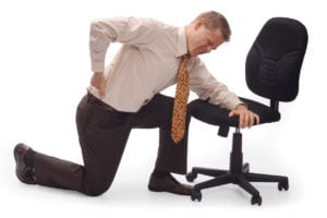 Man kneeling on the floor with back pain on a white background due to herniated disc