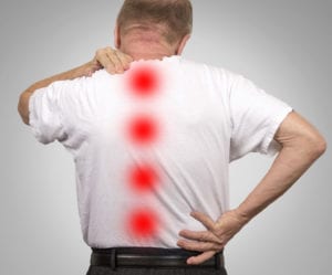 Senior elderly man with backache from spinal stenosis isolated on gray background