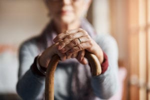 Cropped shot of a senior woman holding a cane in a retirement home Degenerative Disc Disease