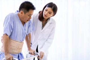 doctor help elderly using adult walker in hospital