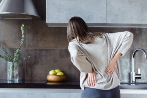 woman in the kitchen experiencing pain from cervical disc herniation