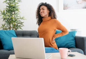 Young black woman suffer back pain while working from home