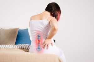 Woman in bed suffering from Spinal Disc Pain.