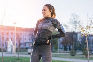 Athletic young woman feeling pain in her back while training outdoors