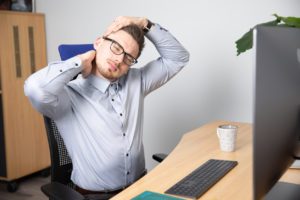 Young businessman with pain in his neck