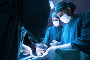 spine surgeon operating spine surgery over patient