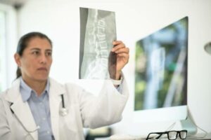 A doctor in her late 30s analyzes an x-ray image.