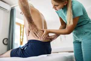 Young physiotherapist working on back pain