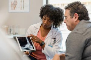 orthopedic surgeon points to x-ray on digital tablet