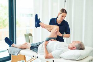 Physiotherapist helping arthritis patient in Exercise
