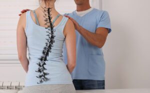 Spine doctor examining a woman with scoliosis