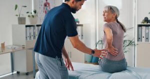 physical therapist helping a patient with back pain.